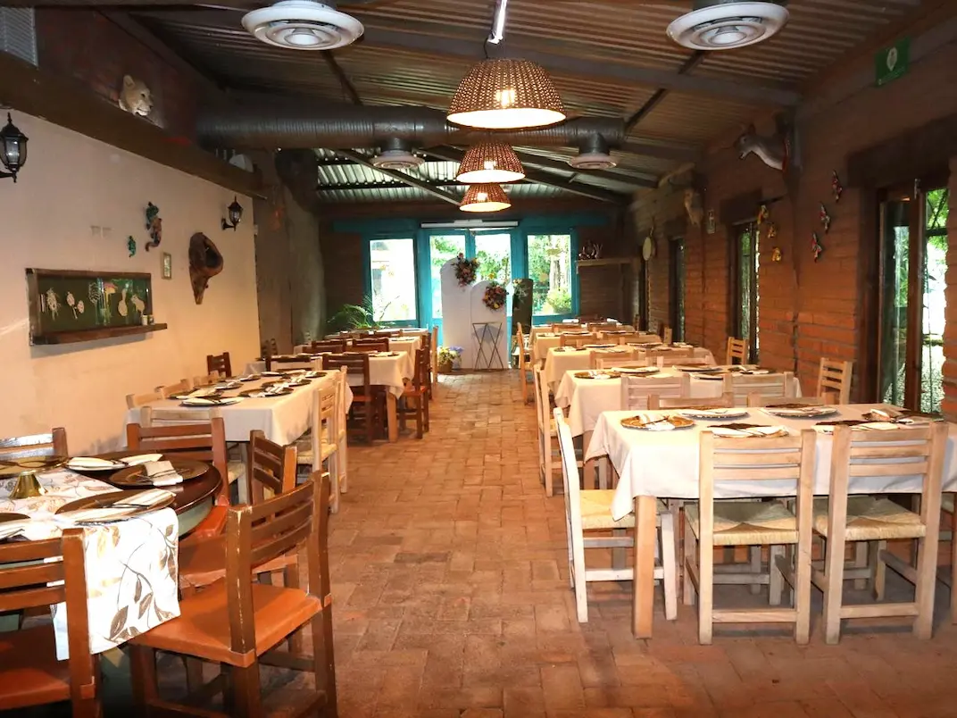 montaje de las mesas del salon grande con platos y manteles